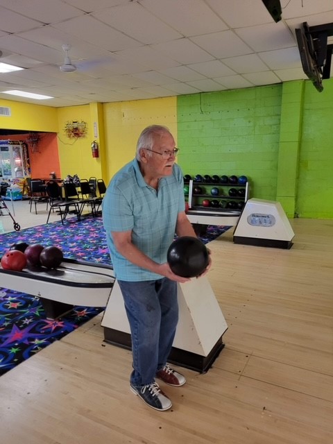 A senior man enjoys bowling during Healthy Aging Month.